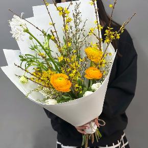 Весенний букет с желтыми ранункулюсами и цветущими ветками форзиции в Егорьевске